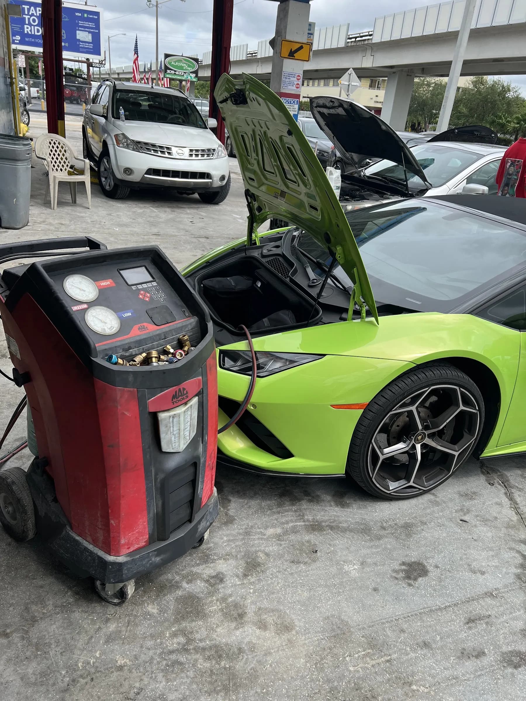 A/C recharge machine connected to a green Lamborghini at J C Car Care Center